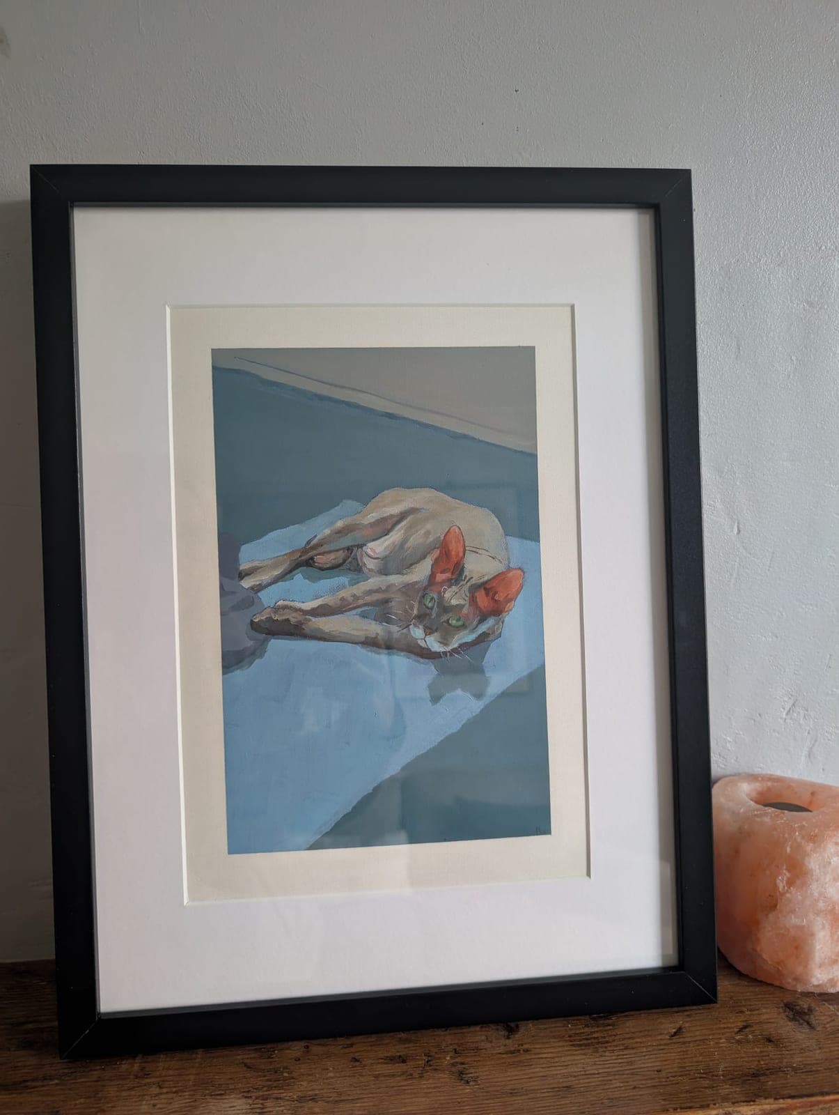 Mounted and framed, leaning against a wall
