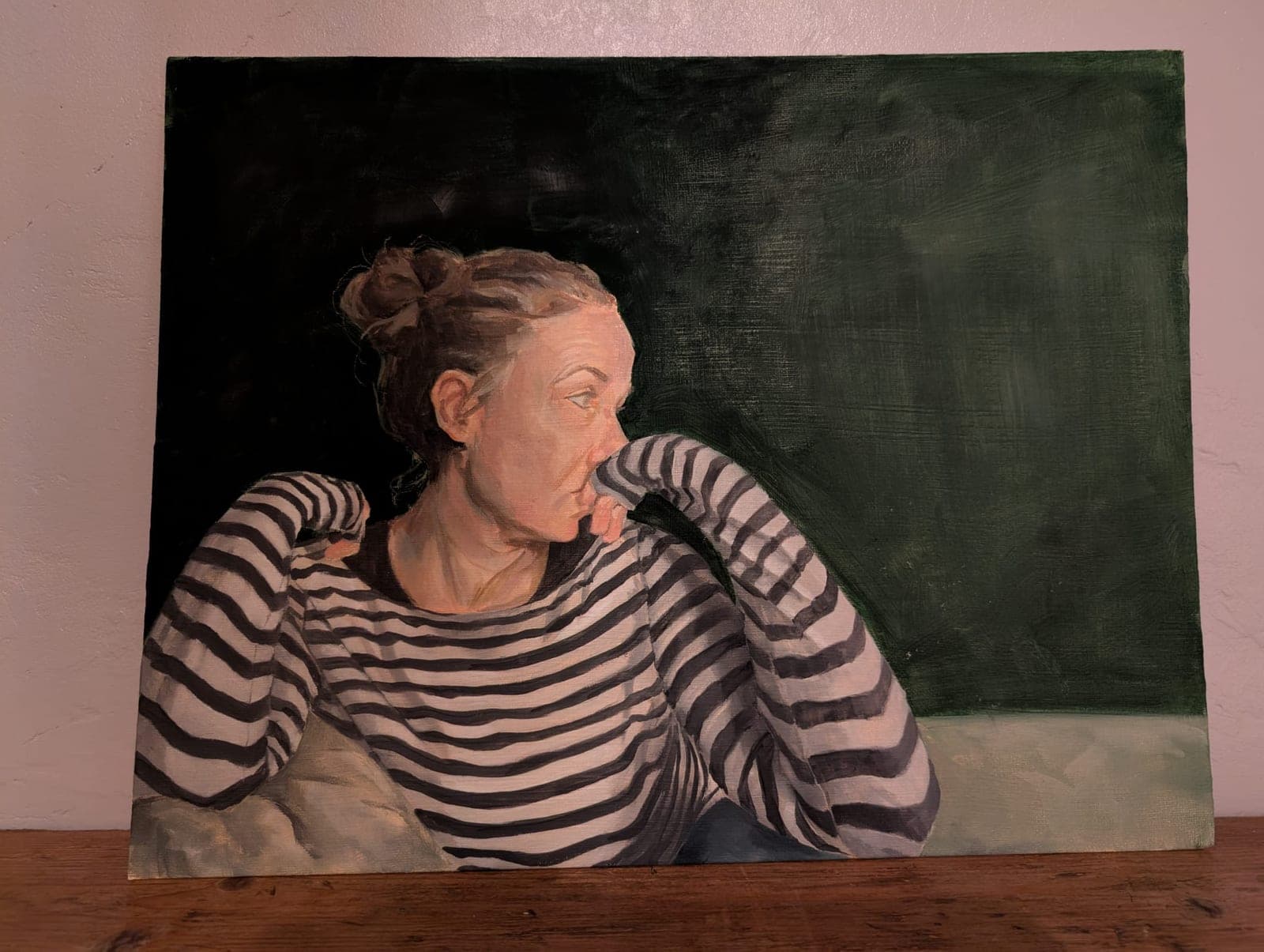 The painting leaning against a wall, unframed